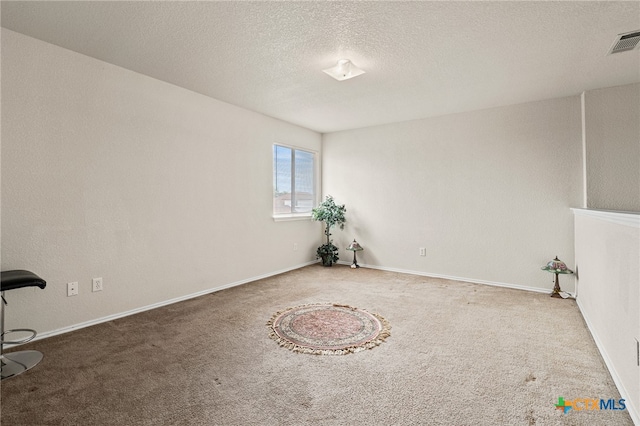 carpeted spare room with a textured ceiling