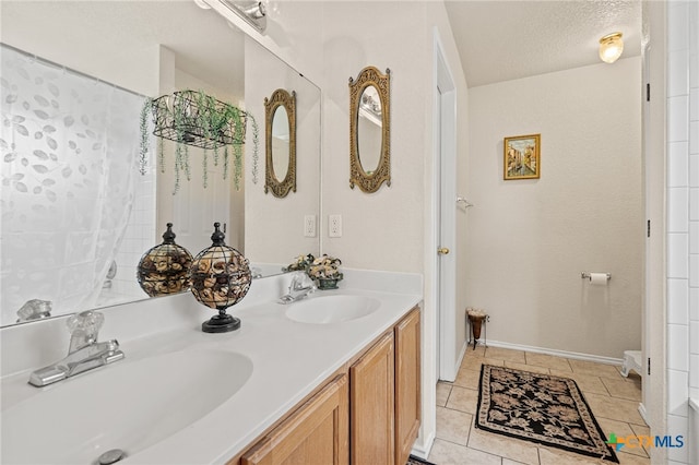 bathroom featuring vanity, a textured ceiling, and tile patterned floors