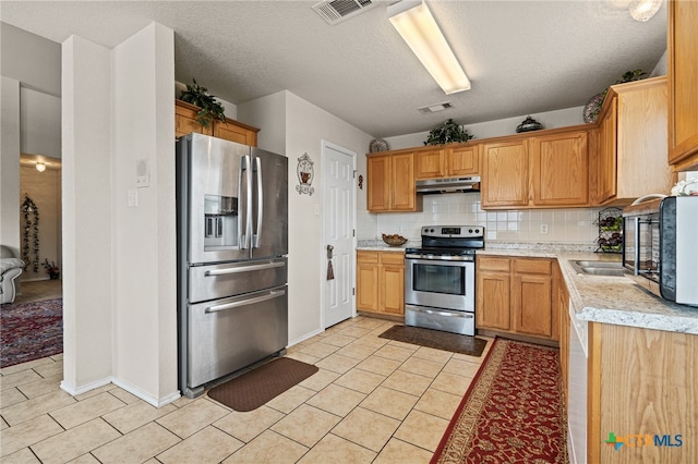 kitchen featuring tasteful backsplash, a textured ceiling, and stainless steel appliances