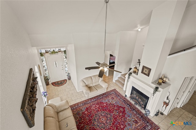 living room with ceiling fan, light tile patterned floors, and vaulted ceiling