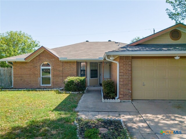 single story home featuring a garage and a front yard