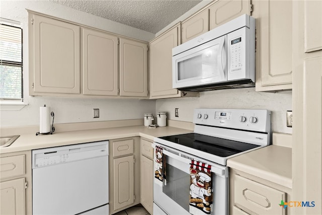 kitchen featuring a textured ceiling and white appliances