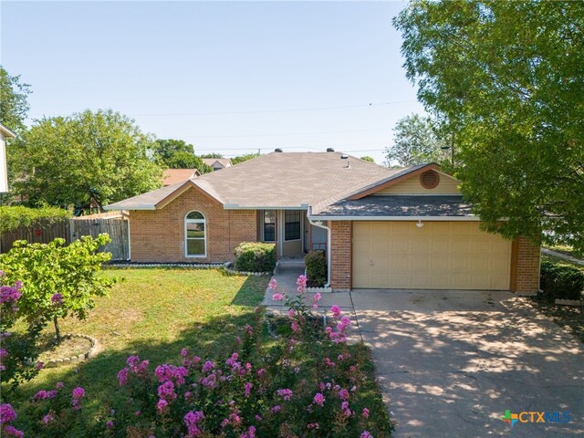 ranch-style home with a garage and a front lawn