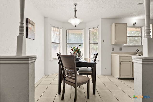 tiled dining area with a wealth of natural light, a textured ceiling, and sink