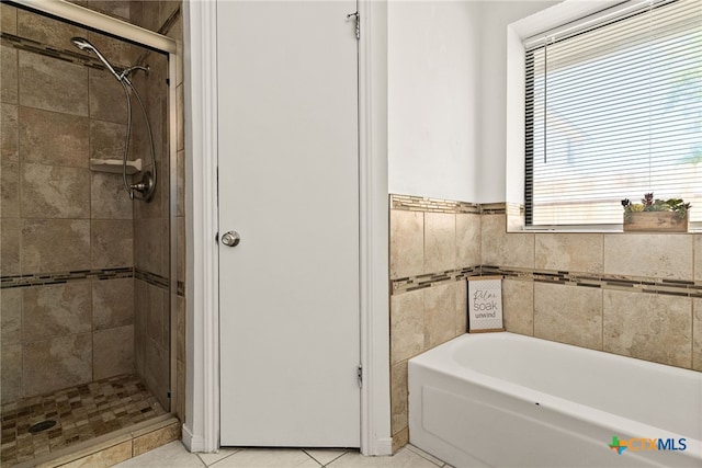 bathroom featuring tile patterned flooring and separate shower and tub