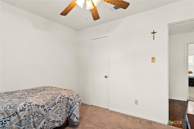 carpeted bedroom featuring a textured ceiling and ceiling fan