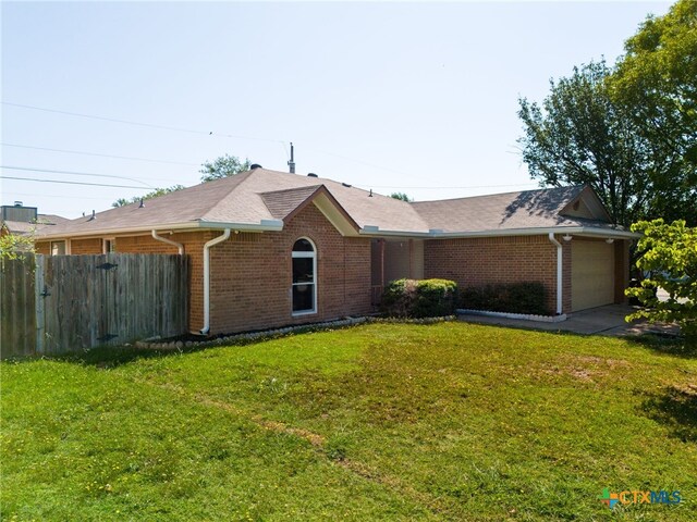 ranch-style house with a garage and a front lawn