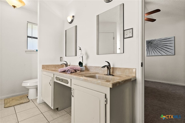 bathroom featuring toilet, vanity, a textured ceiling, and tile patterned flooring