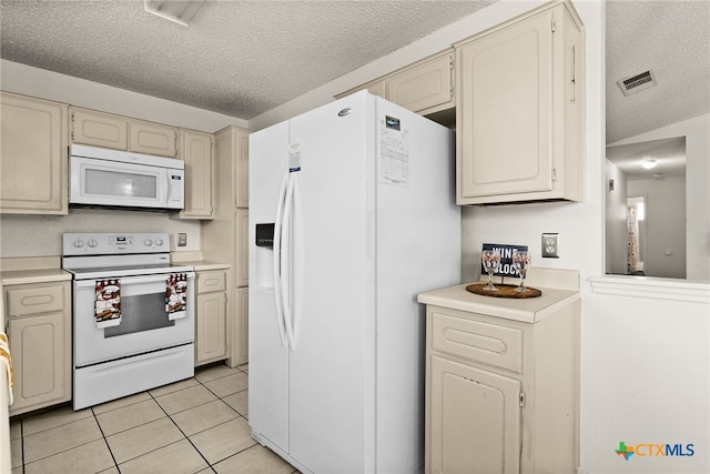 kitchen with white appliances, a textured ceiling, and light tile patterned floors