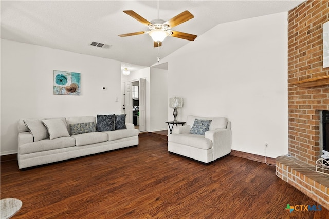 unfurnished living room featuring ceiling fan, vaulted ceiling, dark hardwood / wood-style floors, and a brick fireplace