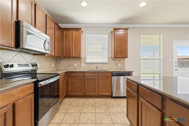 2523 Red Fern Dr, Harker Heights, TX 76548 - kitchen with stainless steel appliances, ornamental molding, backsplash, brown cabinets, and stone countertops