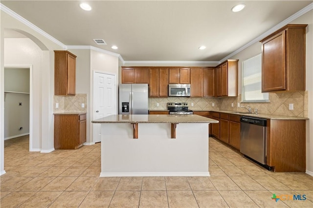 2523 Red Fern Dr, Harker Heights, TX 76548 - kitchen with appliances with stainless steel finishes, arched walkways, decorative backsplash, a center island, and light stone counters
