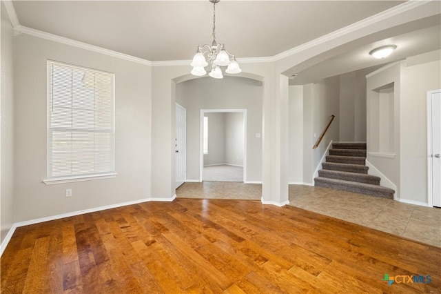 2523 Red Fern Dr, Harker Heights, TX 76548 - empty room featuring arched walkways, a chandelier, wood finished floors, stairs, and ornamental molding