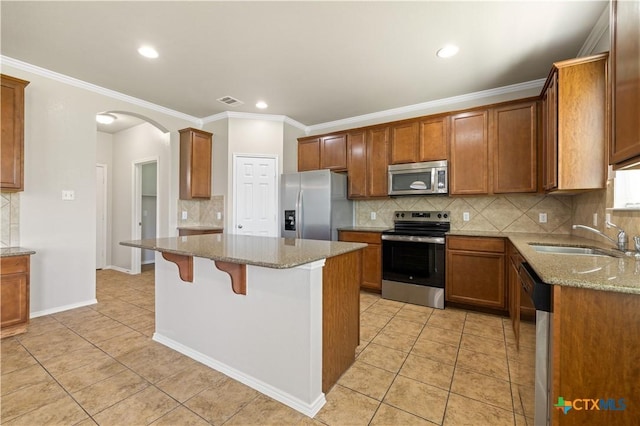2523 Red Fern Dr, Harker Heights, TX 76548 - kitchen featuring appliances with stainless steel finishes, arched walkways, decorative backsplash, light stone countertops, and crown molding