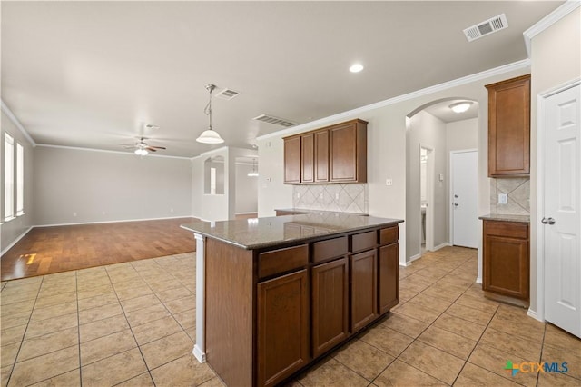 2523 Red Fern Dr, Harker Heights, TX 76548 - kitchen featuring ceiling fan, light tile patterned floors, arched walkways, ornamental molding, and decorative backsplash