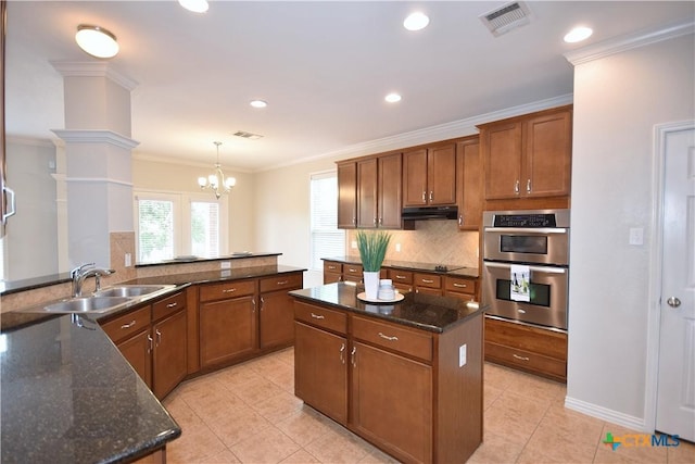 2009 Sandy Point Rd, Harker Heights, TX 76548 - kitchen with under cabinet range hood, stainless steel double oven, backsplash, brown cabinets, and black electric stovetop