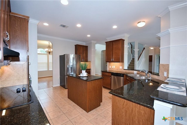 2009 Sandy Point Rd, Harker Heights, TX 76548 - kitchen with stainless steel appliances, decorative backsplash, a center island, ornamental molding, and dark stone countertops