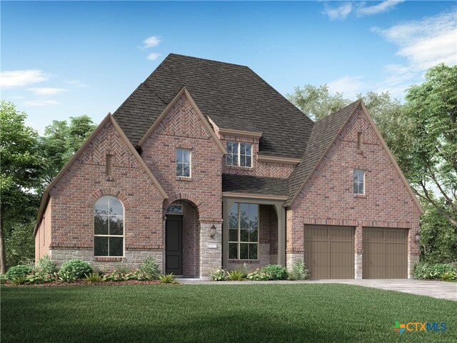 tudor home featuring a garage and a front lawn