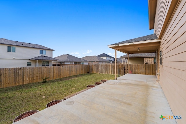 view of yard featuring a residential view, a patio area, and a fenced backyard