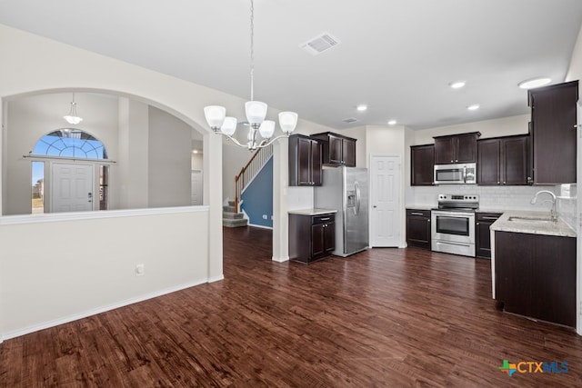 kitchen with a sink, visible vents, hanging light fixtures, appliances with stainless steel finishes, and light countertops