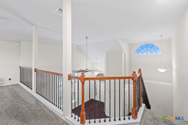 hallway with vaulted ceiling, carpet, an upstairs landing, and visible vents