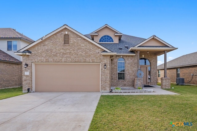 view of front of home featuring cooling unit, a garage, and a front lawn