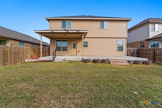 back of house with a yard, a fenced backyard, and a patio