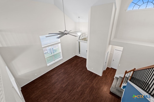 interior space featuring stairway, a ceiling fan, high vaulted ceiling, and dark wood-style flooring