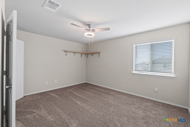 carpeted spare room with visible vents and a ceiling fan