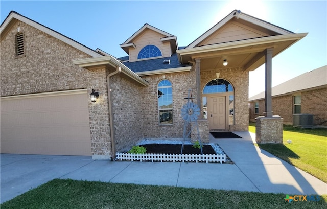 traditional-style home featuring an attached garage, driveway, central AC, and brick siding