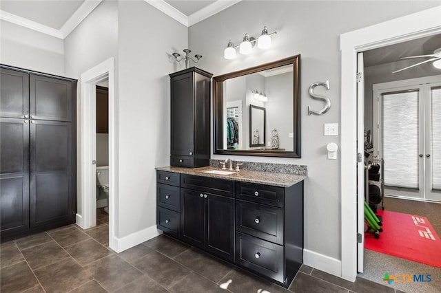 bathroom with toilet, ceiling fan, tile patterned flooring, ornamental molding, and vanity