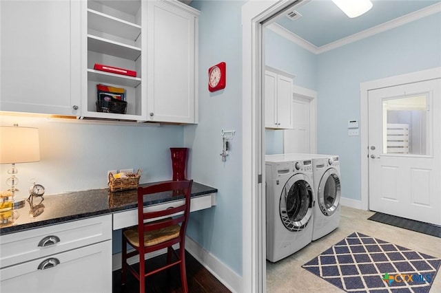 clothes washing area featuring cabinets, ornamental molding, and washing machine and clothes dryer