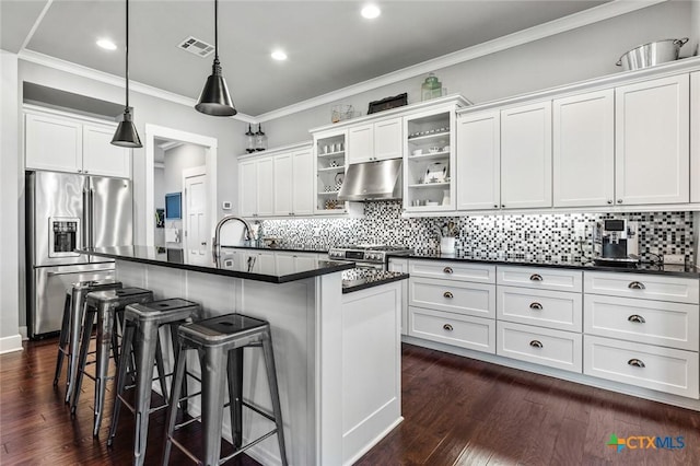 kitchen with pendant lighting, a kitchen bar, white cabinetry, stainless steel appliances, and a kitchen island with sink