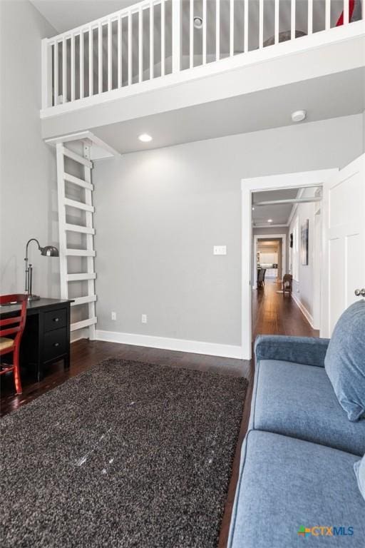 living room featuring a towering ceiling and hardwood / wood-style flooring