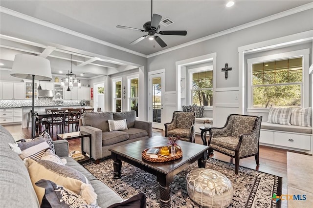 living room featuring coffered ceiling, beam ceiling, wood-type flooring, ornamental molding, and ceiling fan with notable chandelier