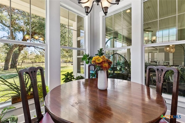 sunroom / solarium featuring an inviting chandelier