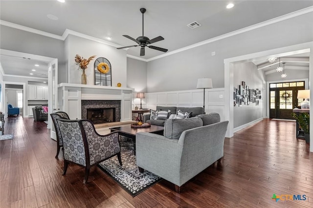 living room with lofted ceiling, dark hardwood / wood-style flooring, ceiling fan with notable chandelier, and ornamental molding