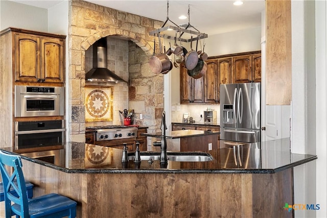 428 Colorado Dr, Cedar Creek, TX 78612 - kitchen with stainless steel appliances, wall chimney exhaust hood, backsplash, a sink, and dark stone counters