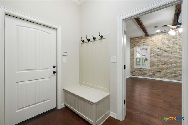 mudroom featuring beam ceiling, dark hardwood / wood-style flooring, brick wall, and ceiling fan