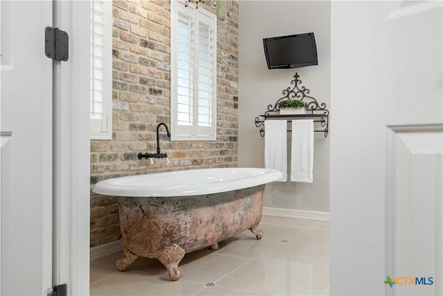 bathroom with tile patterned flooring and brick wall