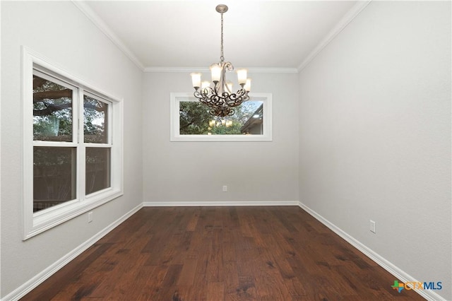 unfurnished dining area featuring dark hardwood / wood-style flooring, ornamental molding, a chandelier, and plenty of natural light