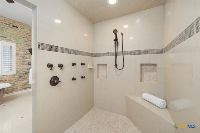 bathroom featuring tile patterned flooring and a tile shower