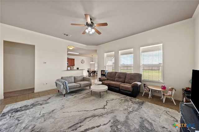 tiled living room with ornamental molding and ceiling fan