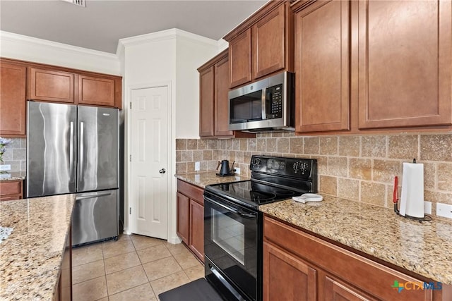 kitchen featuring light stone counters, crown molding, light tile patterned floors, appliances with stainless steel finishes, and backsplash