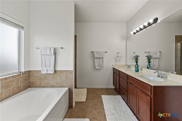 bathroom featuring tile patterned flooring, vanity, and a bath