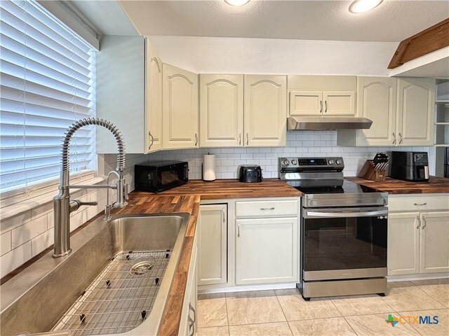 209 Lake Frst, Canyon Lake, TX 78133 - kitchen featuring wooden counters, under cabinet range hood, backsplash, a sink, and stainless steel electric stove