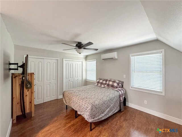 209 Lake Frst, Canyon Lake, TX 78133 - bedroom featuring an AC wall unit, baseboards, multiple windows, wood finished floors, and multiple closets