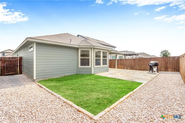 back of house with a yard, a patio area, and a fenced backyard