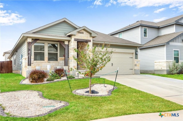 view of front of house with driveway, stone siding, fence, a front yard, and a garage