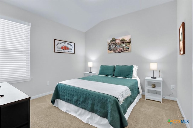 bedroom with baseboards, light colored carpet, and vaulted ceiling